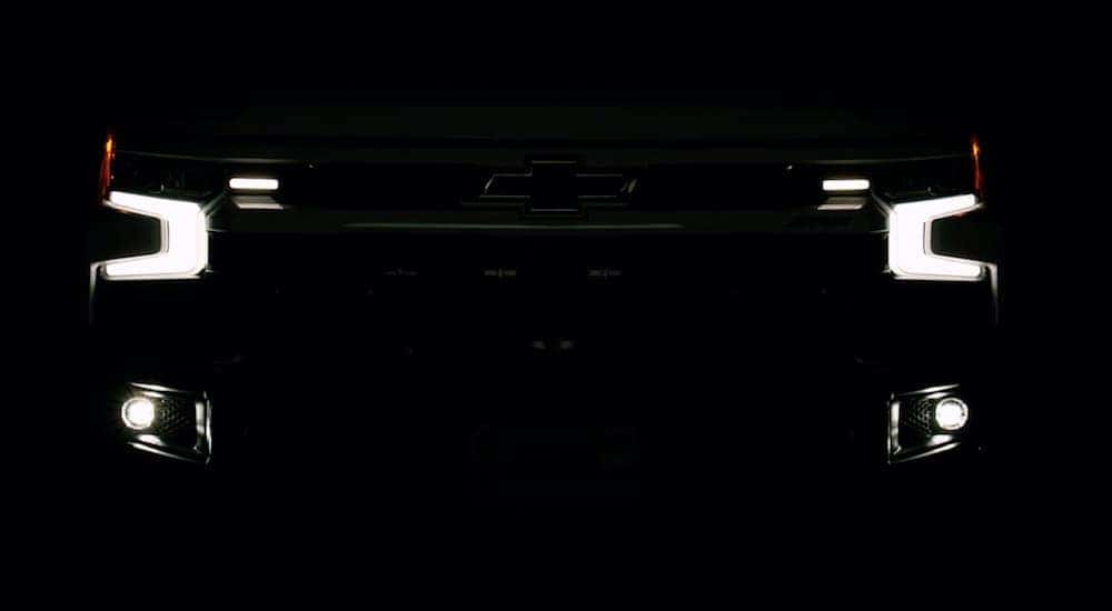 A 2023 Chevy Silverado 1500 ZR2 Bison is shown from the front parked in the dark with headlights on.