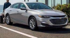 A silver 2021 Chevy Malibu is shown parked.