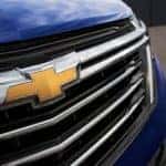 A close up shows the grille and badge on a blue 2022 Chevy Equinox Premier.