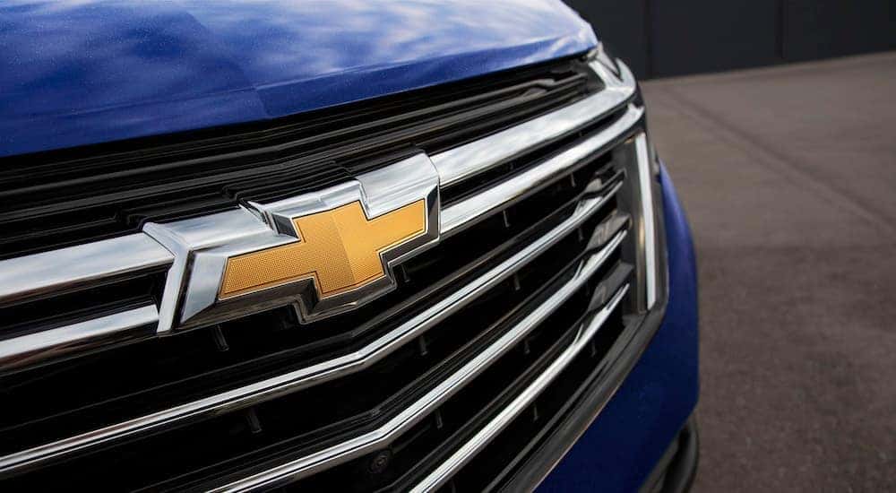 A close up shows the grille and badge on a blue 2022 Chevy Equinox Premier.