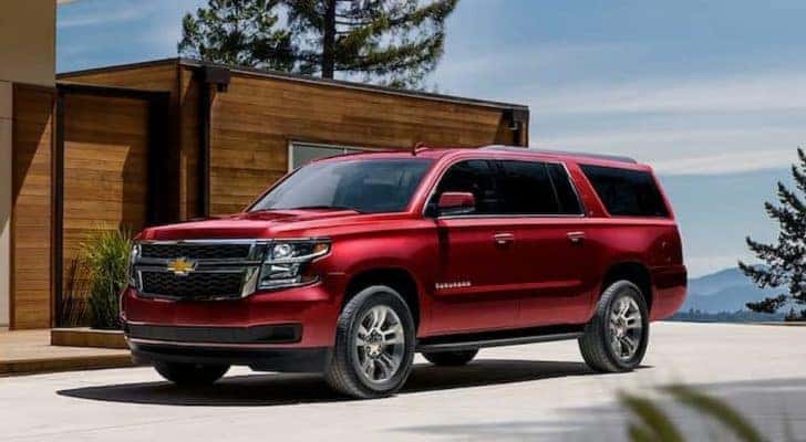 A red 2020 Chevy Suburban is shown parked in a driveway after leaving a used SUV dealership.