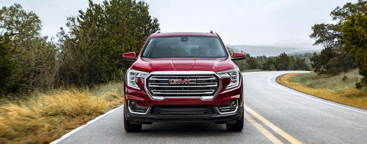 A red 2022 GMC Terrain is shown from the front driving on an open road.