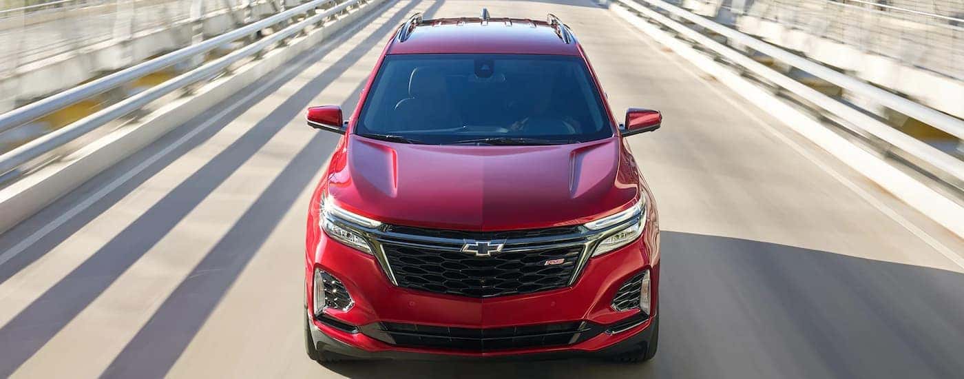 A red 2022 Chevy Equinox RS is shown from a high angled driving on a bridge.