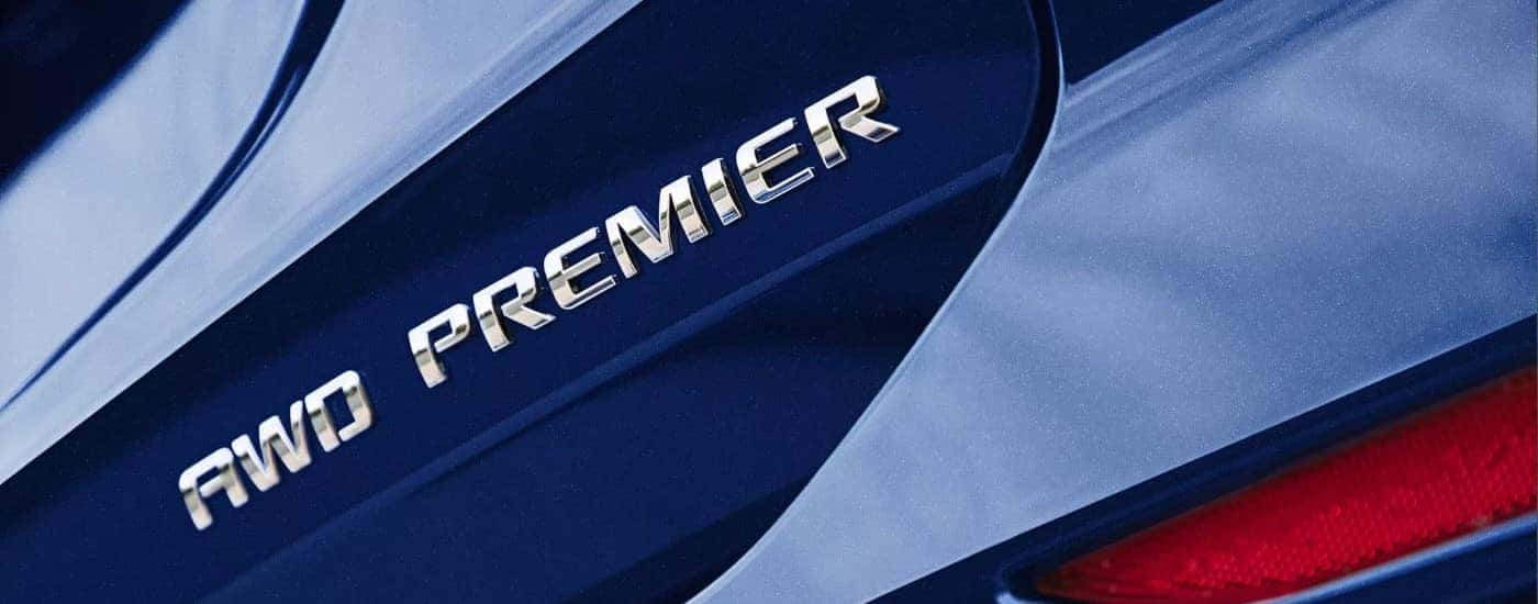 A close up shows the Premier badge on a blue 2023 Chevy Equinox Premier.