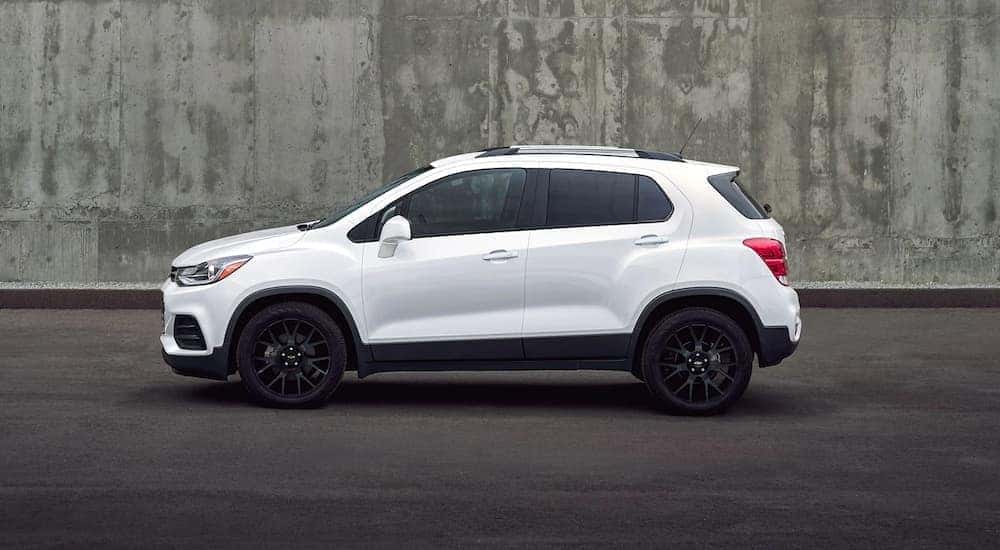 A white 2022 Chevy Trax for sale is shown next to a concrete wall.