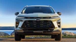 A green 2024 Chevy Trax for sale is shown from the front parked on an empty lot.