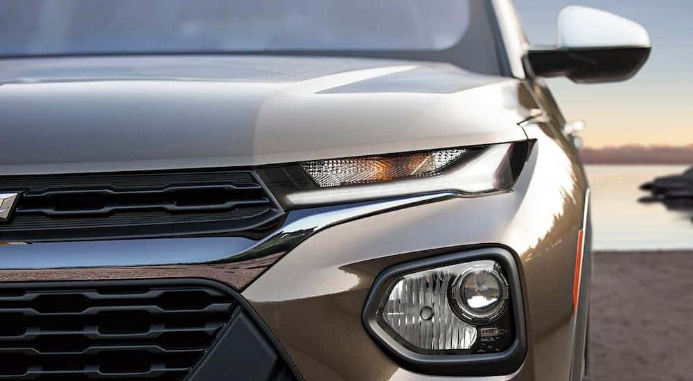 A close up of the headlight on a brown 2022 Chevy Trailblazer is shown after leaving a certified used SUV dealer.