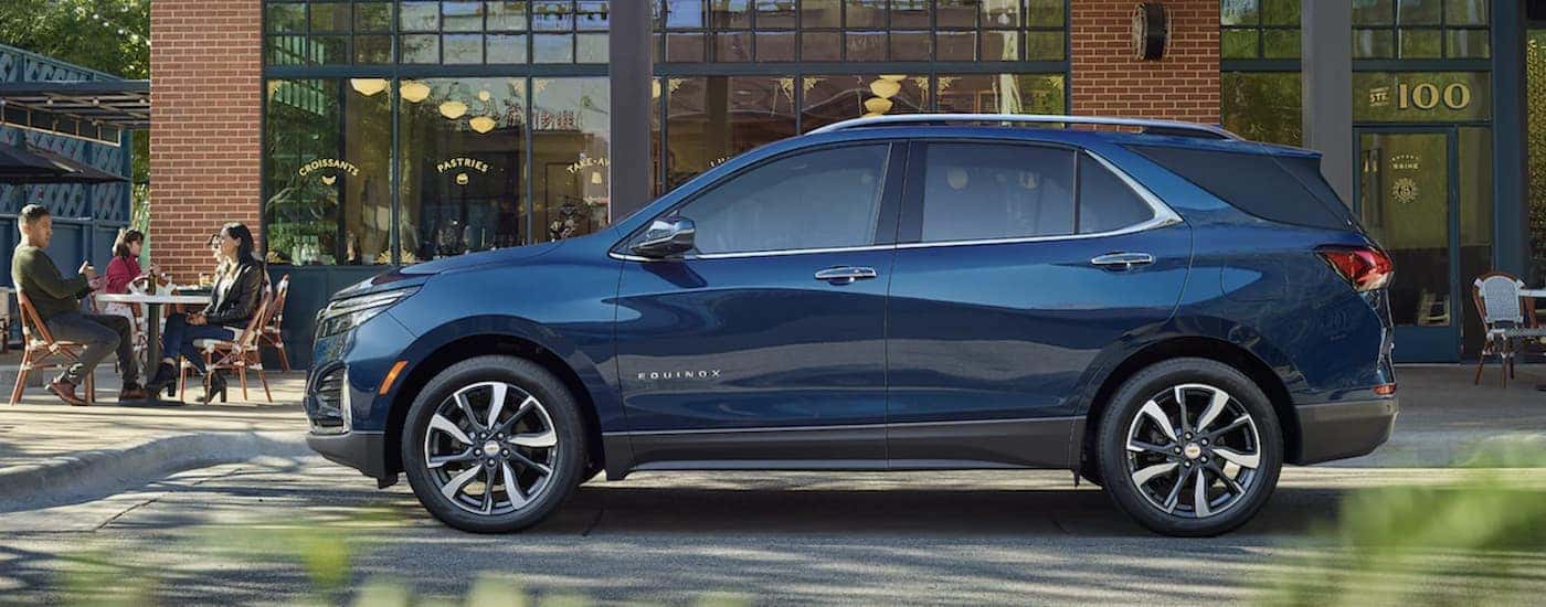 A blue 2022 Chevy Equinox is shown from the side parked in front of a building.