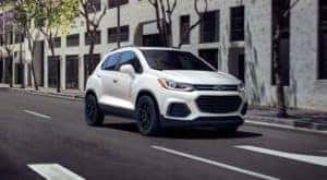 A white 2022 Chevy Trax is shown from the front driving on an open road.