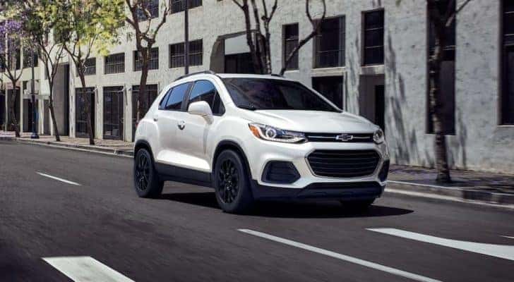A white 2022 Chevy Trax is shown from the front driving on an open road.