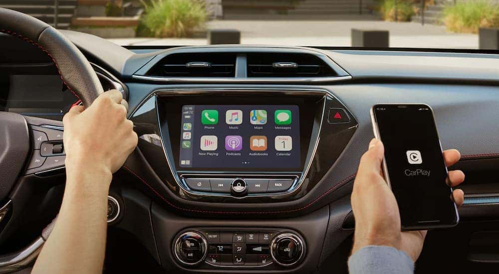 A person is shown using their phone to use carplay in a 2023 Chevy Trailblazer.