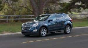 A blue 2016 Chevy Equinox is shown from the side while driving.