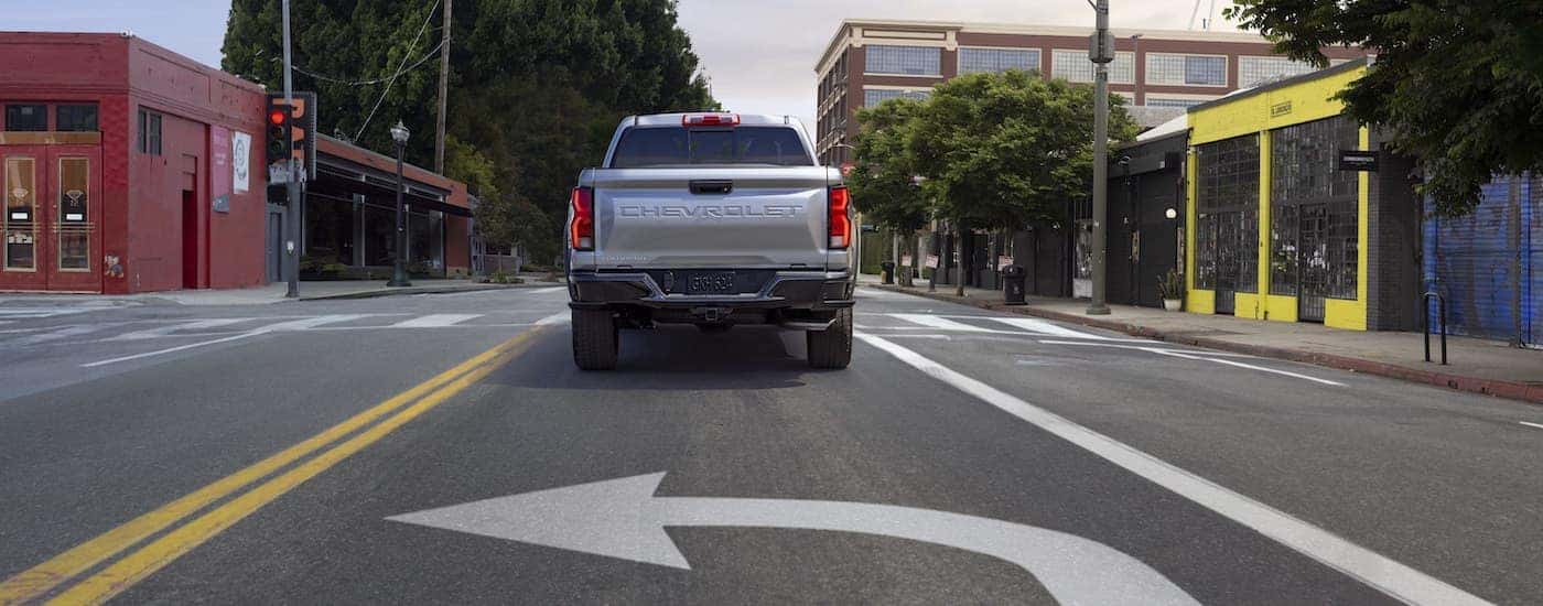 A silver 2023 Chevy Colorado Z71 is shown from the rear while turning.