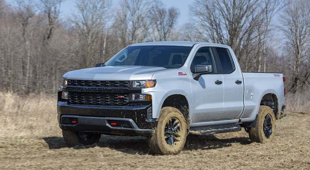 A grey 2023 Chevy Silverado Trail Boss is shown from the front at an angle after leaving a NY Chevy Silverado dealer.