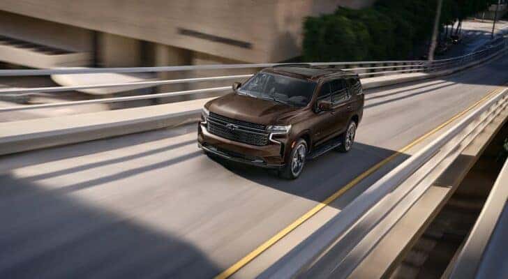 A brown 2022 Chevy Tahoe is shown from the front at an angle after leaving a Saratoga, NY Certified Pre-owned Chevy SUV dealer.