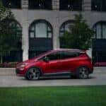 A red 2020 Chevy Bolt EV is shown parked on a road after visiting a Saratoga, NY, Certified Pre-Owned Chevy SUV dealer.