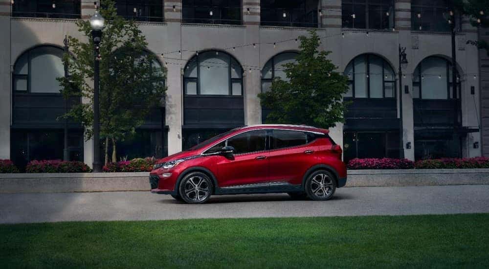A red 2020 Chevy Bolt EV is shown parked on a road after visiting a Saratoga, NY, Certified Pre-Owned Chevy SUV dealer.