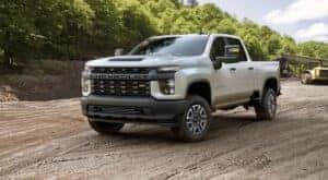 A white 2020 Silverado 2500 HD is shown from the front at angle after leaving a dealer that has a Chevy Silverado 2500 HD for sale.