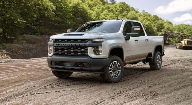 A white 2020 Silverado 2500 HD is shown from the front at angle after leaving a dealer that has a Chevy Silverado 2500 HD for sale.