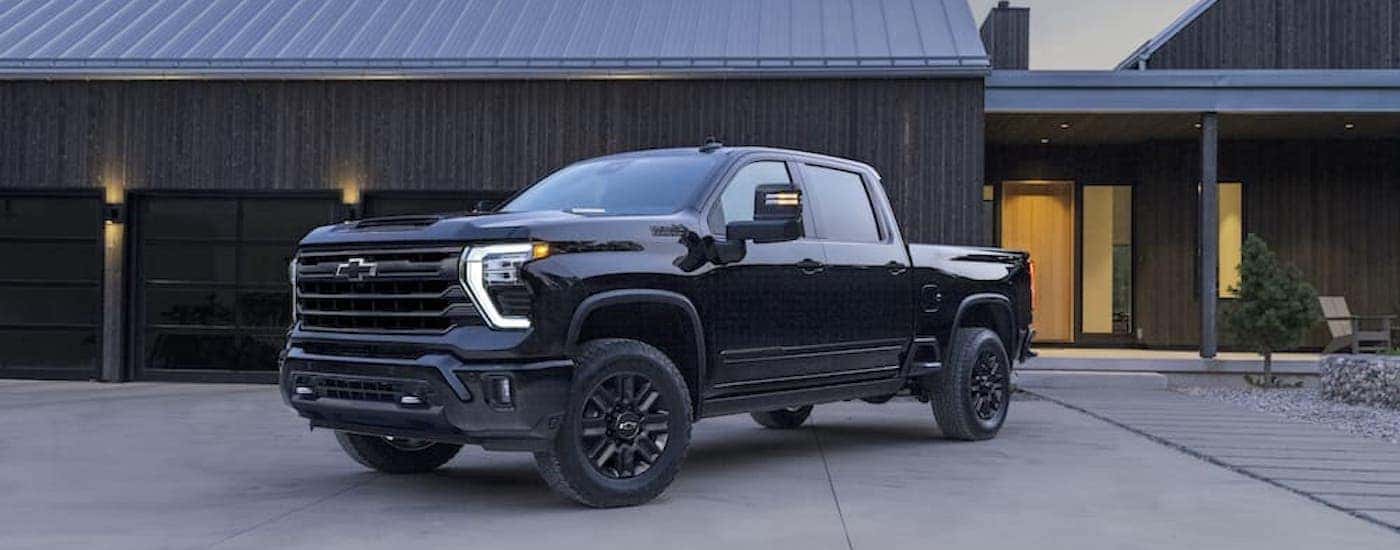 A black 2024 Chevy Silverado 2500 HD High Country is shown from the front at an angle.