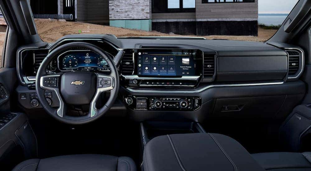 The black interior of a 2023 Chevy Silverado 3500 HD is shown from the driver's seat.