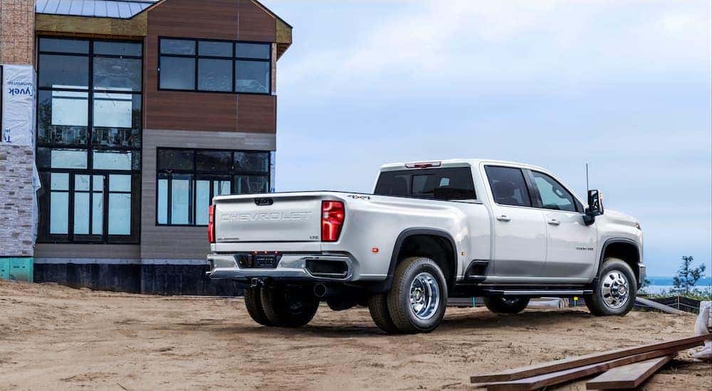 A white 2024 Chevy Silverado 3500 HD is shown from the rear at an angle after leaving a dealer that has a Chevy Silverado 3500 HD for sale.