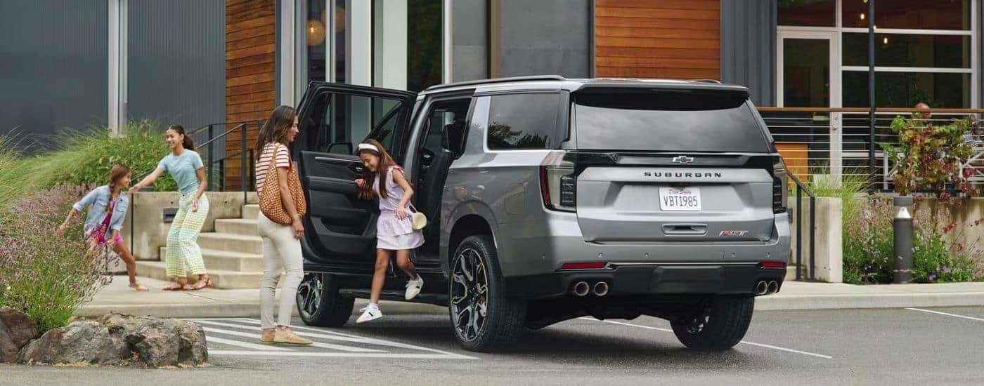 Family near a grey 2025 Chevy Suburban RST