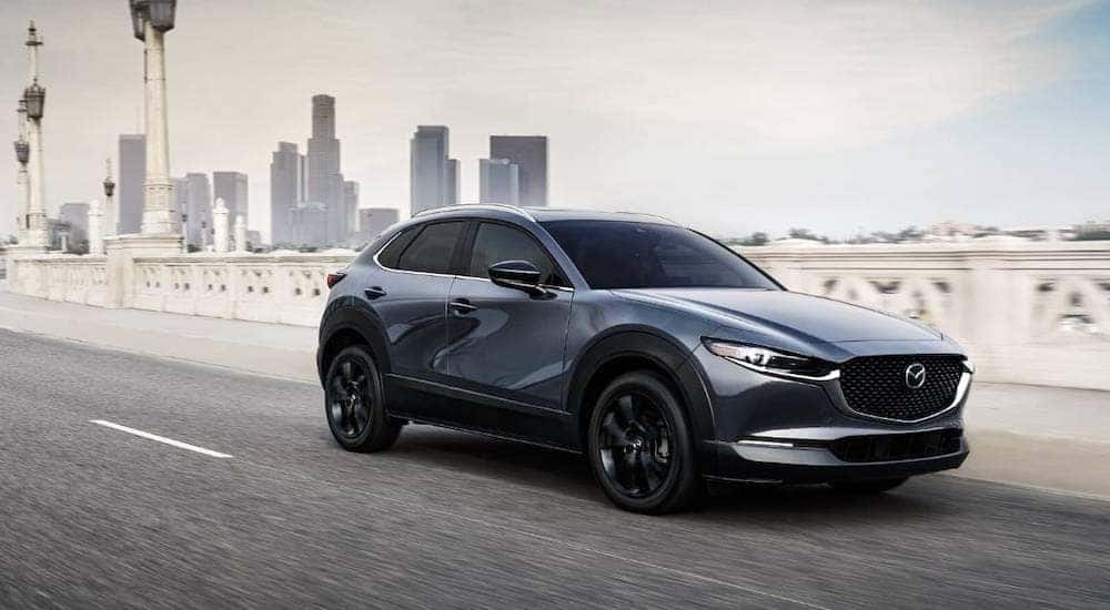 A grey 2022 Mazda CX-30 Turbo is shown from the front at an angle after leaving a dealer that has Used cars for sale near Colonie, NY.