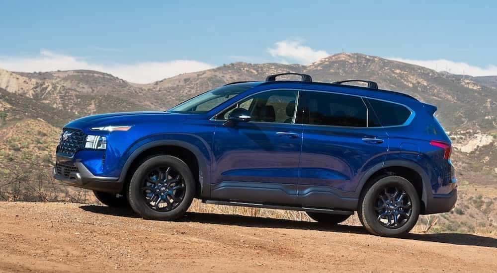 A blue 2022 Hyundai Santa Fe is shown from the side while off-road.