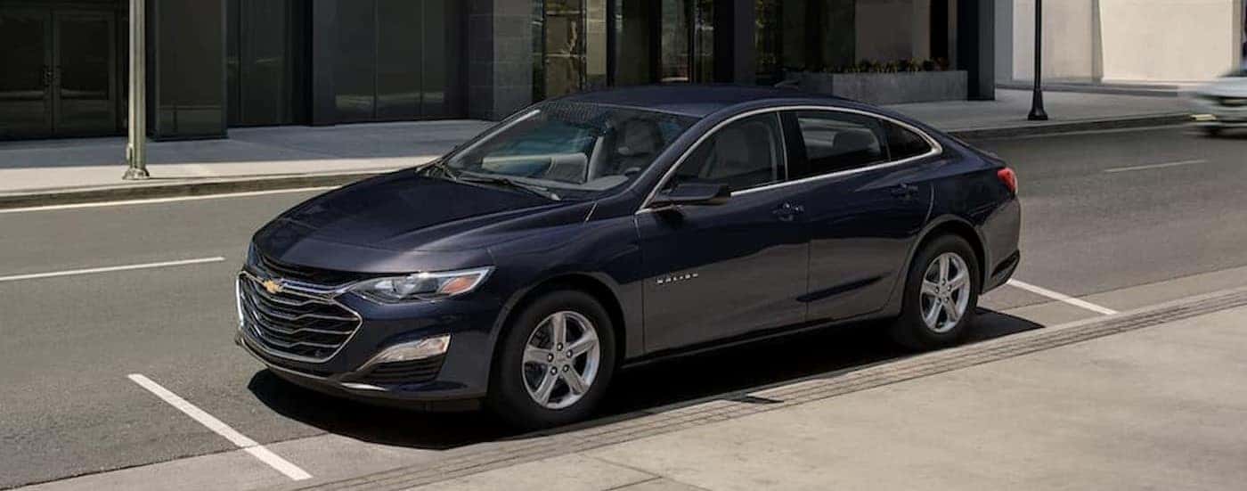 A dark blue 2023 Chevy Malibu is shown parked on a city street.