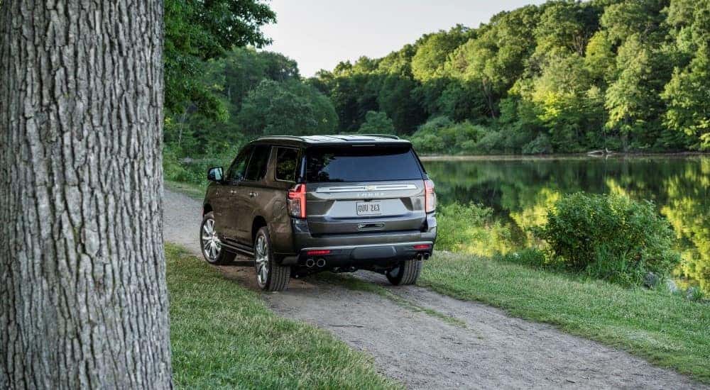 A grey 2021 Chevy Tahoe High Country is shown near a lake after leaving a Chevy dealer near Amsterdam.