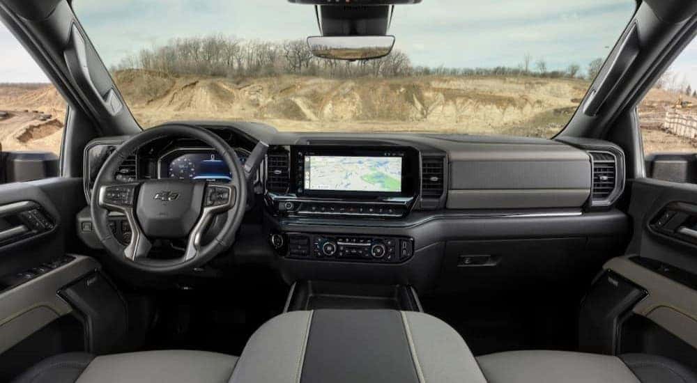 The black and gray interior and dash of a 2024 Chevy Silverado 1500 for sale is shown.