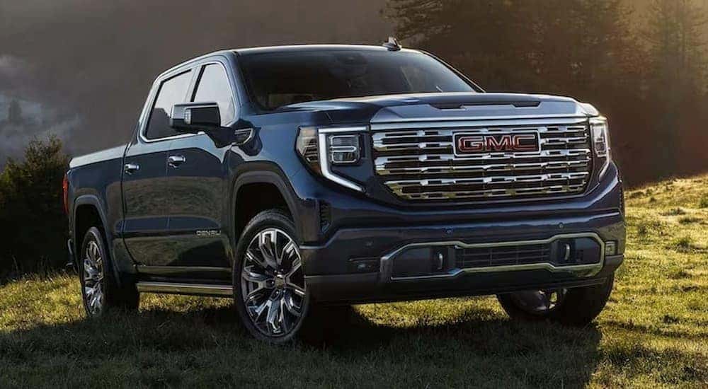 A blue 2023 GMC Sierra 1500 Denali is shown parked off-road.