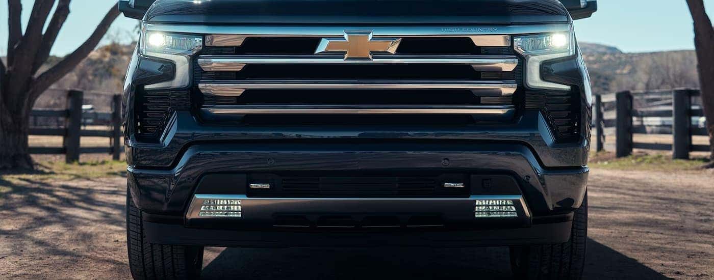 A close up of the grille on a popular Chevy truck for sale, a black 2024 Chevy Silverado 1500 High Country, is shown.