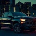A black 2024 Chevy Silverado 1500 Custom is shown from the front at an angle.