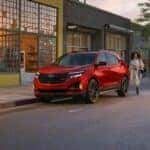 A red 2024 Chevy Equinox RS is shown parked near a Chevy dealer near Cohoes.