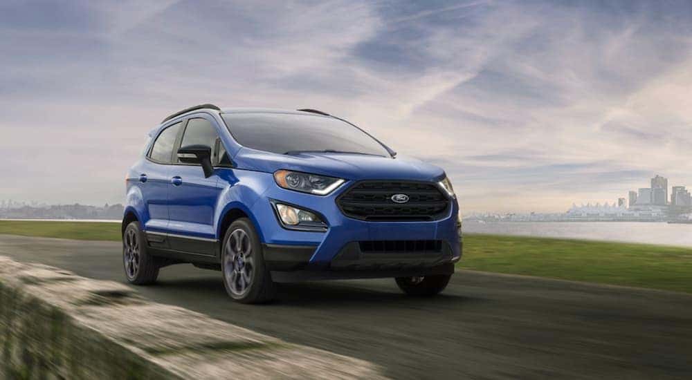 A blue 2020 Ford EcoSport is shown driving near a city.