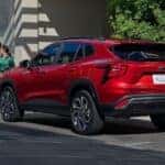 A red 2024 Chevy Trax is shown parked on a city curb after a 2024 Chevy Trax vs 2024 Mitsubishi Outlander Sport comparison.