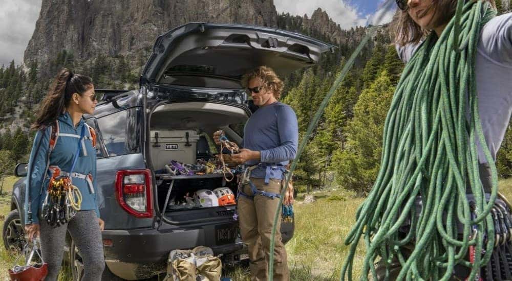 A blue 2024 Ford Bronco Sport is shown parked near several rope climbers.