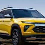 After competing in a 2024 Chevy Trailblazer vs 2024 Ford Bronco Sport comparison, a yellow 2024 Chevy Trailblazer is shown parked near a lake.