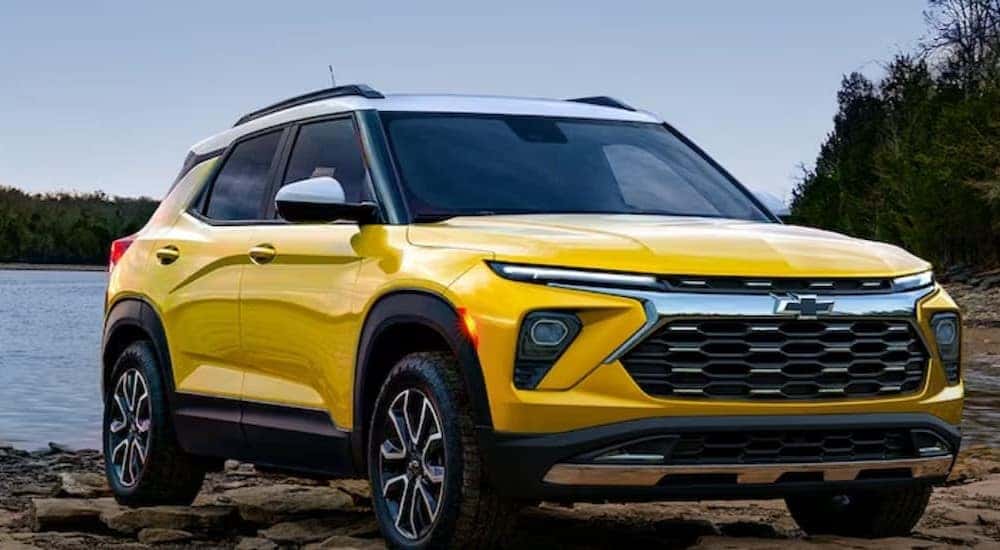 After competing in a 2024 Chevy Trailblazer vs 2024 Ford Bronco Sport comparison, a yellow 2024 Chevy Trailblazer is shown parked near a lake.