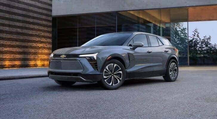 A popular Chevy Blazer EV for sale, a gray 2024 Chevy Blazer EV, is shown parked near a building.