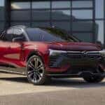 A red 2024 Chevy Blazer EV for sale is shown parked outside a building.