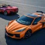 A red and an orange 2024 Chevy Corvette Z06 are shown from a high angled parked on pavement.