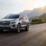 A silver 2024 Chevy Equinox driving on a mountain highway.