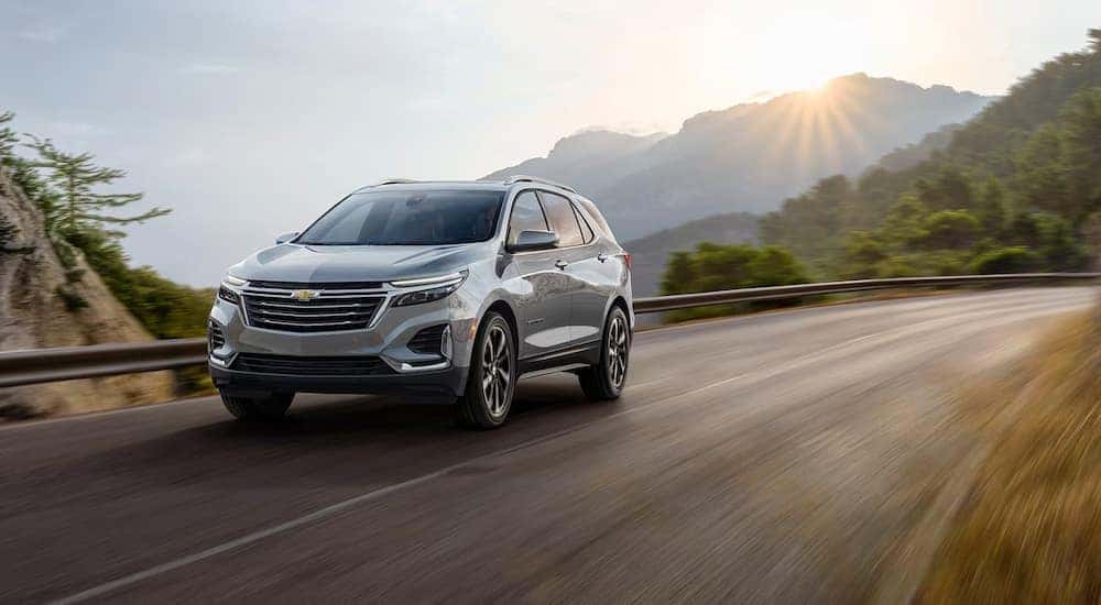 A silver 2024 Chevy Equinox driving on a mountain highway.