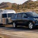 A black 2021 Chevy Suburban towing an airstream trailer.