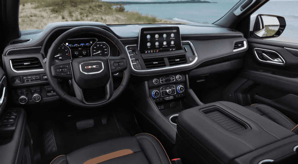 The front seats and infotainment screen of a 2021 GMC Yukon AT4, one of many used SUVs for sale near Colonie.