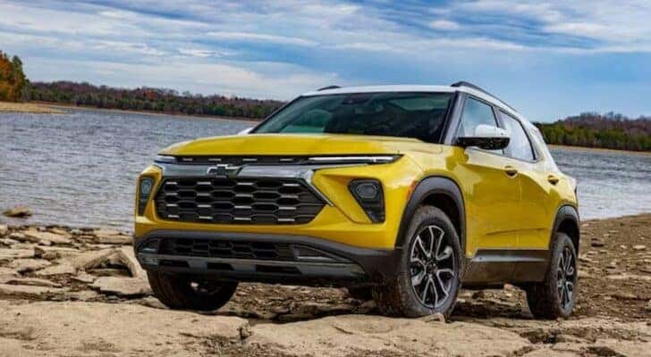 A yellow 2023 Chevy Trailblazer is shown parked near an ocean after viewing used SUVs for sale near Colonie.