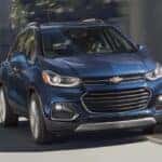 A blue 2020 Chevy Trax is shown driving in a city.
